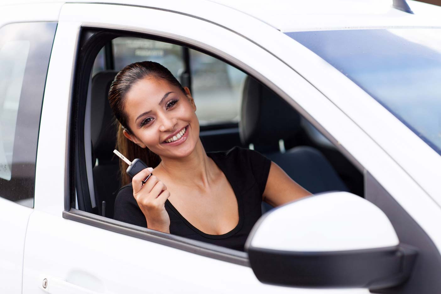 Happy woman in driving seat of car